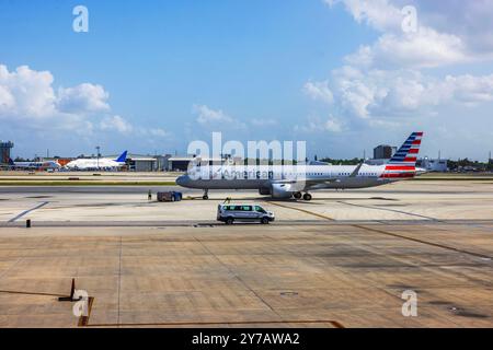 American Airlines fliegen auf Asphalt am Miami International Airport, mit Bodenbesatzung und Fahrzeugen bei klarem, sonnigem Wetter. Miami. USA. Stockfoto