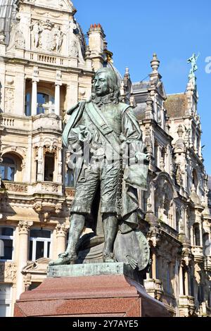 Statue des Malers David Teniers II. In Antwerpen mit seiner Palette; dahinter befinden sich große neobarocke Gebäude in der Meir, Antwerpens bester Einkaufsstraße Stockfoto