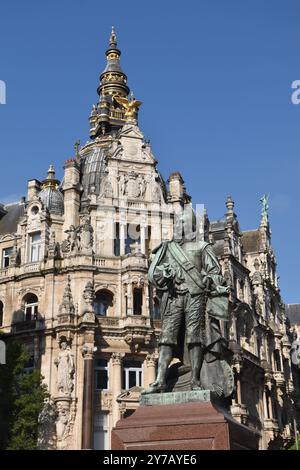 Statue des Malers David Teniers II. In Antwerpen mit seiner Palette; dahinter befinden sich große neobarocke Gebäude in der Meir, Antwerpens bester Einkaufsstraße Stockfoto