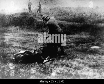 Ein deutscher Soldat, der einen Gefangenen erschießt, der auf dem Boden im Dorf Jajinci liegt. Das Dorf Jajinci bei Belgrad diente als Hinrichtungsort für Häftlinge aus dem Konzentrationslager Banjica. Stockfoto