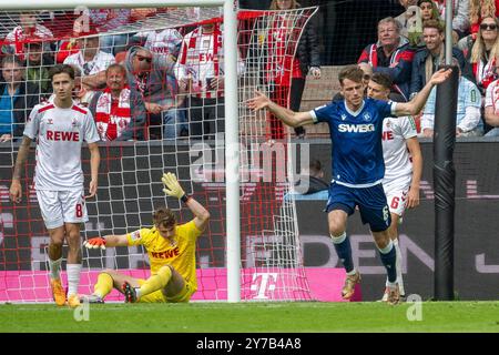 29.09.2024, Fußball: 2. Bundesliga, Saison 2024/2025, 07. Spieltag, 1. FC Köln gegen Karlsruher SC im RheinEnergieStadion in Köln. Waehrend die Spieler Denis Huseinbasic (1. FC Köln, #08), Jonas Urbig (1. FC Köln, #40) und Eric Martel (1. FC Köln, #06) ueber das Tor zum 3:4 enttaeuscht sind hebt Leon Jensen (Karlsruher SC, #06) jubelnd die Arme. Wichtiger Hinweis: Gemaess den Vorgaben der DFL Deutsche Fussball Liga bzw. Des DFB Deutscher Fussball-Bund ist es untersagt, in dem Stadion und/oder vom Spiel angefertigte Fotoaufnahmen in Form von Sequenzbildern und/oder videoaehnlichen Fotostreck Stockfoto