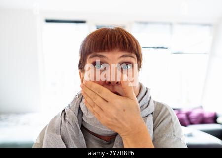 Portrait Frau mittleren Alters niest, hustet, bedeckt ihren Mund mit der Hand, Stockfoto