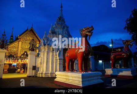 Ein Paar Löwenstatuen, die am Abend beim Sonnenuntergang vor Wat Phra That Hariphunchai Woramahawihan zu sehen sind. Wat Phra That Hariphunchai Woramahawihan liegt im Herzen von Lamphun und ist ein bedeutender Tempel im Norden Thailands, der die Stadt Lamphun symbolisiert. Die heilige Stupa bewahrt Reliquien des Buddha und wurde während der Regierungszeit von König Athitayarat um 1108 n. Chr. erbaut. Der Tempel verfügt über eine atemberaubende Lanna-Architektur und ist ein verehrter Ort, an dem Buddhisten zum Gottesdienst kommen. Stockfoto