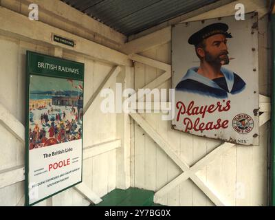 Vintage British Railways (BR) und Plakate für Players Werbung in Midsomer Norton Station, Somerset. British Rail, Zugfahrt, Zigaretten, Rauchen. Stockfoto