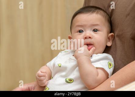 Daumen oder Finger saugen die Angewohnheit des Neugeborenen für Ruhe und Entspannung. Asiatische Säuglinge öffnen den Mund und stecken die Finger in das Saugen, fühlen sich sicher an. Baby ne Stockfoto