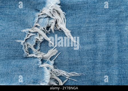 Struktur der zerrissenen Jeans. Denim-Hintergrund mit Fransen Stockfoto