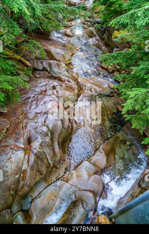 Wasser rauscht an Felsen im Denny Creek im Bundesstaat Washington vorbei. Stockfoto