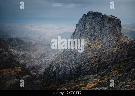 Die zerklüfteten, malerischen Berge von Serra da Estrela stehen hoch unter bewölktem Himmel, ihre felsigen Gipfel schaffen eine dramatische Szene im wolkigen Wetter Stockfoto