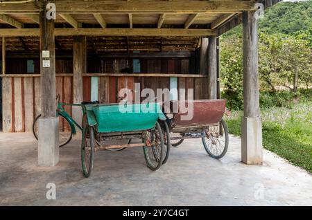 Alte Rikschas parkten unter einem Haus in Kampot in Kambodscha Stockfoto