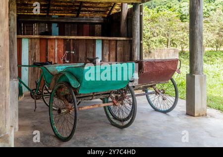 Alte Rikschas parkten unter einem Haus in Kampot in Kambodscha Stockfoto