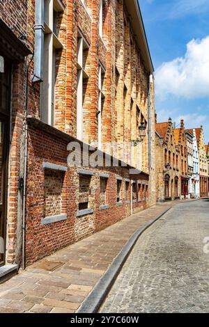 Straße in Brügge. Typische farbenfrohe Stadthäuser mit Pyramidenfassade und gepflasterter Straße mit Kopfsteinpflaster. Brügge, Belgien, Europa Stockfoto