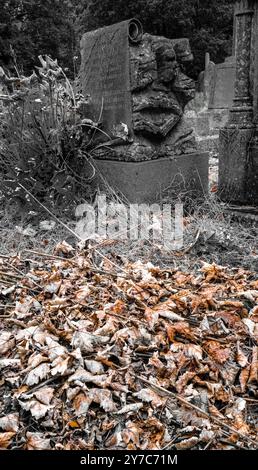 Gräber auf einem viktorianischen Friedhof in Whitchurch Village, Cardiff, Wales, Großbritannien. . Entsättigungseffekt auf dem Foto. Verfallende Blätter. Stockfoto