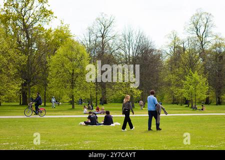 London, England, April 30 2023: Blick auf die Gärten der Kensington Gardens mit Menschen, die im Gras spazieren gehen Stockfoto