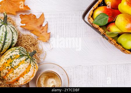 Speisen im Herbst-Stil mit Kaffee, Kürbissen, Birnen und Herbstblättern auf einem Tisch für eine gemütliche, saisonale Atmosphäre. Enthält Kopierraum für Stockfoto