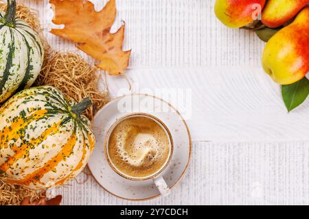 Speisen im Herbst-Stil mit Kaffee, Kürbissen, Birnen und Herbstblättern auf einem Tisch für eine gemütliche, saisonale Atmosphäre. Enthält Kopierraum für Stockfoto