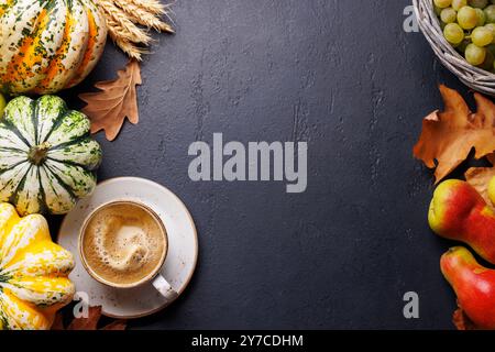 Herbstmotive mit Kürbissen, Birnen, Trauben und Herbstblättern auf einem Tisch für eine gemütliche, saisonale Atmosphäre. Enthält Kopierraum für Stockfoto