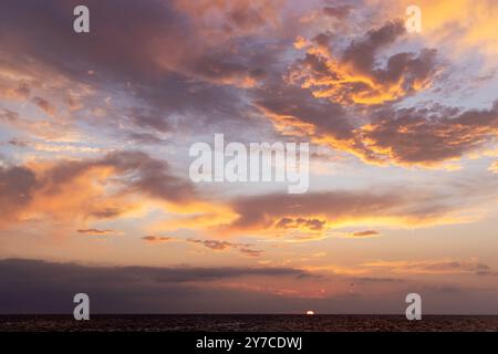 Ein dramatischer und stimmungsvoller Sonnenuntergang voller dunkler, wirbelnder Wolken, die ein Gefühl von Mysterium und Atmosphäre wecken Stockfoto