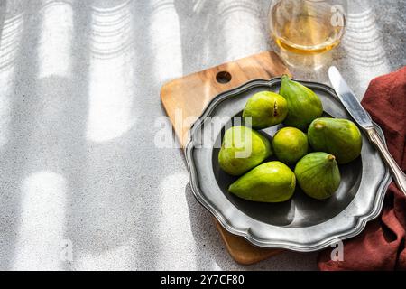 Reife grüne Feigen und Brie-Käse, serviert mit trockenem Weißwein zum Abendessen als Vorspeise Stockfoto