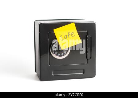 Kleiner Safe mit Kombinationsschloss und gelber Haftnotiz. Stockfoto