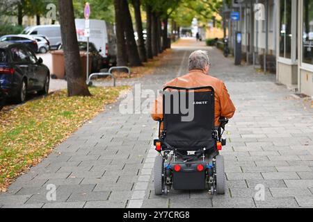 München, Deutschland. September 2024. Rentner, Mann fährt in einem elektrischen Rollstuhl, Rollstuhl auf einem Bürgersteig in München? Quelle: dpa/Alamy Live News Stockfoto