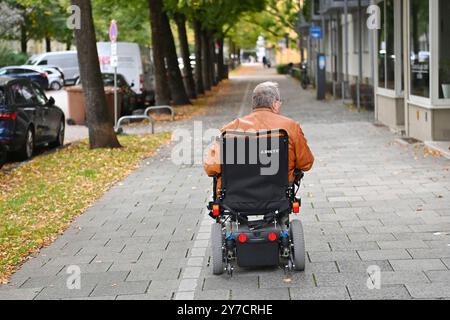 München, Deutschland. September 2024. Rentner, Mann fährt in einem elektrischen Rollstuhl, Rollstuhl auf einem Bürgersteig in München? Quelle: dpa/Alamy Live News Stockfoto