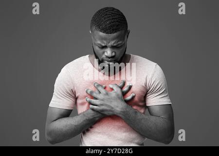 Trauriger junger Mann mit akuten Schmerzen in der Brust Stockfoto