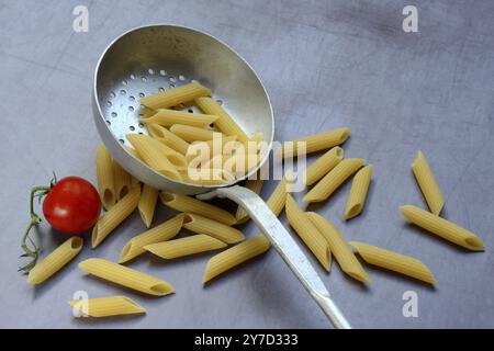 Pasta, italienische Penne in einer Siebkelle Stockfoto