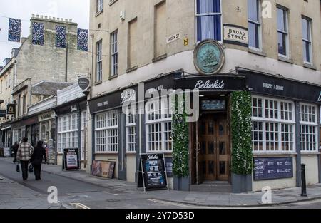 24. April 2024 Fußgänger passieren Belushi's Pub an der Kreuzung von Broad Street und Green Street in der City of Bath, Somerset England auf einem ruhigen Achterbahngang Stockfoto