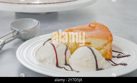 Ein Stück von einem frisch gebackenen Apfelkuchen mit Schlagsahne, serviert mit Vanilleeis und Schokolade Nahaufnahme auf einem weißen Teller Stockfoto