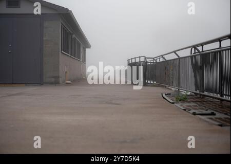 Niedriger Blick auf das alte Ziegelgebäude und das Geländer verschwinden im Nebel Stockfoto