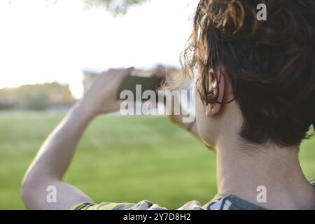 Ein Nahaufnahme-Typ macht Fotos von der Natur, schöne Aussichten auf seinem Smartphone. Sommerstimmung Stockfoto