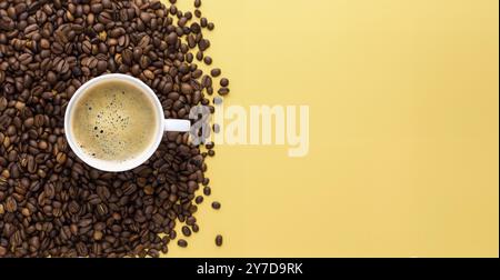 Internationaler Kaffeetag, eine Tasse Arabica-Kaffeebohnen auf gelbem Hintergrund Stockfoto