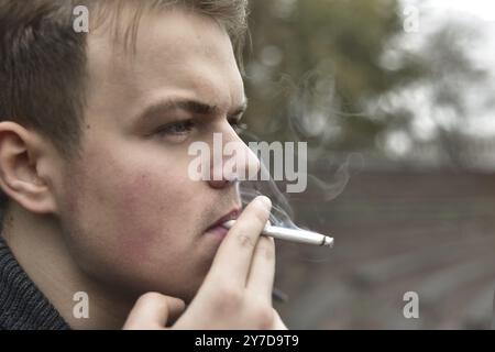 Kerl, raucht eine Zigarette draußen, Porträt, Nahaufnahme Stockfoto