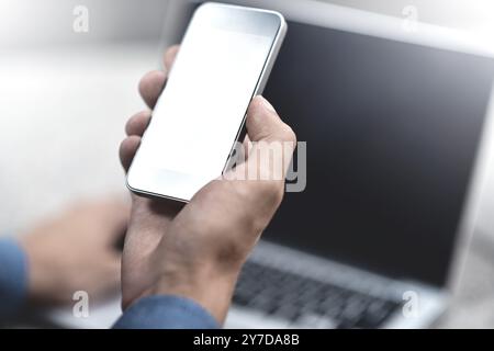 Zugeschnittenes Bild einer jungen Frau, die Anwendungen und Multimediaprogramme per Smartphone herunterlädt, mit Laptop auf der Straße in der modernen Stadt Stockfoto