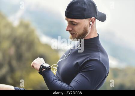 Nahaufnahme Bärtiger Sportiver Mann nach dem Training überprüft die Fitness-Ergebnisse. Erwachsener Mit Sport-Tracker-Armband Stockfoto