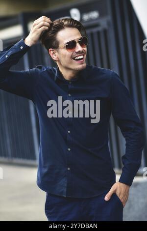 Junge stilvoll und sicher glücklich gut aussehender Geschäftsmann Modell in shirt Lifestyle in der Straße in Sonnenbrille Stockfoto
