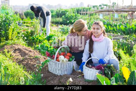 Eine Farmerin und ihre Tochter im Teenageralter halten einen Weidenkorb in der Hand Stockfoto