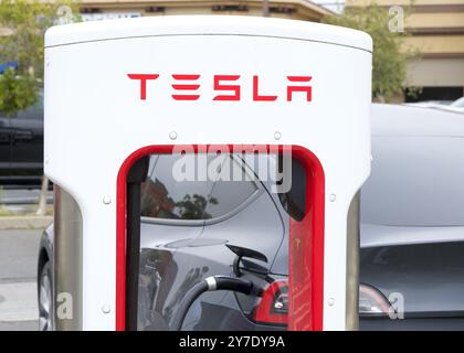 Alameda, KALIFORNIEN - 25. Mai 2024: Nahaufnahme der Tesla Supercharging Station an EV angeschlossen. Tesla Kompressorstationen ermöglichen eine schnelle Aufladung von Tesla-Fahrzeugen Stockfoto