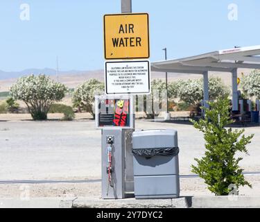 Coalinga, CA - 29. Mai 2024: Luft- und Wasserstation an einer lokalen Tankstelle, tesla-Station im Hintergrund. Nach dem kalifornischen Gesetz müssen die Stationen fr Stockfoto