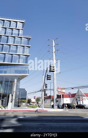 Fotos mit Stromleitungen, Straßenecken und Autos mit klarem blauen Himmel und städtischer Infrastruktur im Hintergrund. Stockfoto