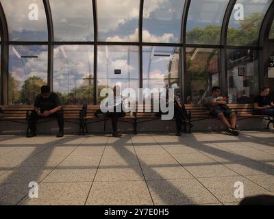 Fremde vertieften sich am Bahnhof Summit, New Jersey, in ihre Handys, während sie sich der Umgebung nicht bewusst waren. Stockfoto