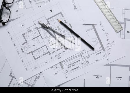 Verschiedene Architekturzeichnungen, Lineal, Trennwand, Bleistift und Gläser auf dem Tisch, flache Lagen Stockfoto