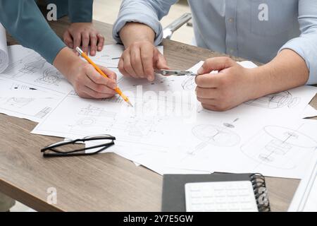 Ingenieure arbeiten mit Projekt, Nahaufnahme. Verschiedene technische Zeichnungen auf Holztisch Stockfoto