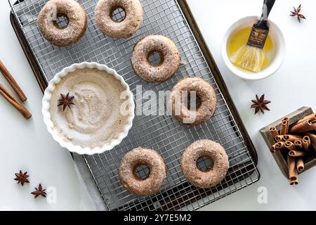 Hausgemachte Donuts auf einem Kühlregal mit Zimtzucker und geschmolzener Butter. Stockfoto