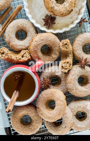 Ein Kühlregal mit Donuts, Zimtzucker und einer Tasse Apfelwein. Stockfoto