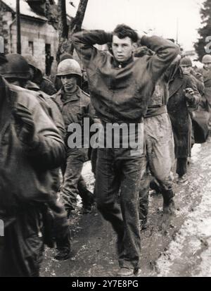 Ein amerikanischer Soldat führt mit den Händen hinter dem Kopf eine Akte der alliierten Kriegsgefangenen an, die von deutschen Truppen während ihrer Winteroffensive an der Westfront gefangen genommen wurden. Diese Offensive, im Westen als Ardenschlacht bekannt, war ein deutscher Versuch, die alliierten (meist US-amerikanischen) Linien in Frankreich zu durchbrechen und an die Kanalküste vorzudringen. Die Deutschen hatten nicht annähernd die Stärke, um erfolgreich zu sein, aber sie gaben den Verbündeten eine sehr böse Überraschung, und es dauerte sechs Wochen und etwa 180.000 Opfer, um aufzuhören. Es war die blutigste Schlacht, die die US-Armee im 2. Weltkrieg ausführte. Stockfoto