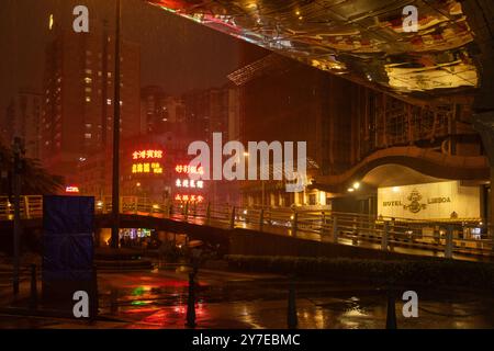 Macau Neonlichter im Regen mit leuchtenden Schildern, die sich auf der Straße spiegeln Stockfoto
