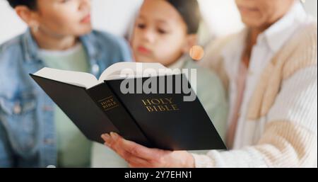 Mutter, Kind und Großmutter mit Bibel in Händen seit Generationen, Gottesdienst und Religionsunterricht. Zuhause, Frauen und kleines Mädchen mit Schriften im Haus Stockfoto