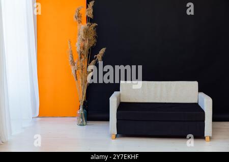 Schwarzes graues Sofa im Zimmer mit Blumendekor Stockfoto