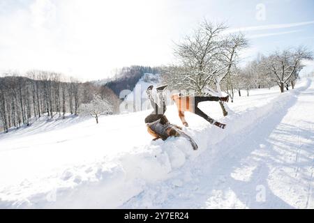 Freunde, die Spaß haben, in hohen Schnee springen. Der erste Schneefall der Saison. Stockfoto